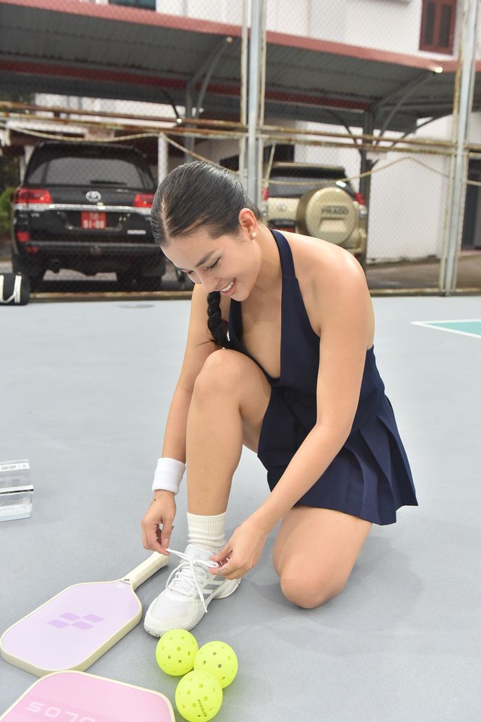 services-bg Young woman prepares for a game of pickleball by tying her sneakers on the court.